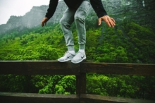 Trampolin Test - Junge balanciert auf Zaun